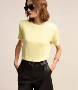 Blusa amarilla de algodón con cuello redondo, mangas cortas y hombreras.