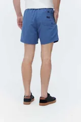 Short de baño azul, de corte clásico y largo corto, con cintura elástica y cordón ajustable bicolor. Cuenta con bolsillos laterales y uno trasero.