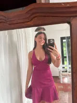 Vestido corto negro con estampado de plumas doradas, escote en V, breteles finos cruzados en la espalda, cut-outs laterales y volado en el ruedo.