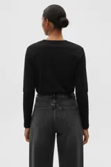 Remera de manga larga, color negro, con cuello redondo y un bolsillo de parche en el pecho.