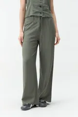 Pantalón de corte ancho y tiro medio, color verde militar, con cintura elástica ajustable mediante cordón y bolsillos laterales.