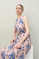Vestido largo sin mangas de silueta fluida, color rosado con estampado floral abstracto en azul.