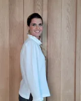 Camisa de manga larga con estampado de rayas verticales en tonos crudo y beige. Presenta cuello alto con volados, cierre frontal con botones dobles y puños con volados.