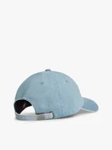 Gorra de béisbol Tommy Jeans de estilo vintage, confeccionada en tejido denim de algodón con efecto desteñido en los bordes y costuras. Cuenta con diseño de seis paneles, ojales de ventilación, visera curva con costuras texturizadas, hebilla de ajuste metálica en la parte trasera y parche con el logo de la marca en el frente.