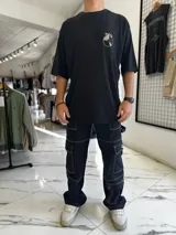 Remera oversize blanca de manga corta, con gran estampado en la espalda de una bandeja de vinilos y texto temático musical.