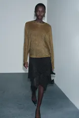 Jersey de punto con cuello redondo, manga larga ancha y puños ajustados. Tejido con hilo metalizado en tonos marrones y dorados.