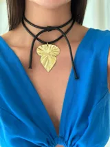 Gargantilla negra con dije de hoja dorada.