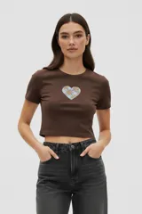Remera de algodón color marrón, de corte crop y ajuste al cuerpo, con cuello redondo y aplique central en forma de corazón con estampado a cuadros.