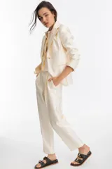 Blazer color crema confeccionado en tafeta, con cierre de un botón y mangas largas.