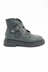 Bota corta de cuero lavado en tono gris oscuro, con suela track robusta y dos correas con hebillas metálicas en el lateral. Presenta un detalle de estrella metálica pequeña en la correa superior.