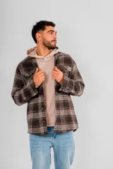 Sobrecamisa de hombre con cuello camisero, botones frontales y bolsillos de parche en el pecho. Presenta un estampado a cuadros en tonos marrones, negros y beige.