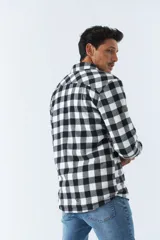 Sobrecamisa de algodón a cuadros color ladrillo, con interior de corderito, cierre con botones, bolsillos tipo cartera y logo en goma. El modelo usa talle M.