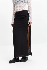 Falda larga negra de calce recto con tajo lateral alto y detalle fruncido en un lateral de la cintura.