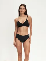 Conjunto de ropa interior negro, compuesto por un corpiño triangular con tirantes finos y una bombacha tipo culotte de cobertura total.