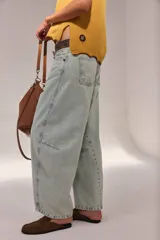 Pantalón jean de algodón con corte barrel y tiro bajo, de color azul, con bolsillos delanteros y traseros.