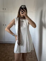 Bufanda tejida artesanalmente con hilado fantasía de textura abierta y brillo sutil. Es una pieza liviana y versátil que puede usarse como bufanda o mini chal.