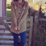 Cárdigan marrón de lana merino con botones al frente y flores bordadas.