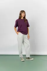 Pantalón jogger de calce relajado color bordó intenso, con cintura elastizada y lazo regulable. Cuenta con bolsillos laterales con cierre invisible y silueta recta levemente afinada.