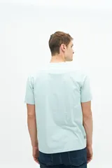 Remera celeste de manga corta con estampado de peces y texto en el frente.