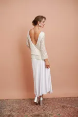 Blusa blanca con bordado de mostacillas y lentejuelas, escote redondo y manga larga.