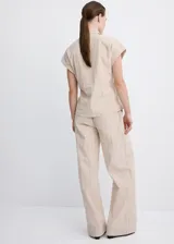 Pantalón recto color beige de tiro medio, con estampado de raya diplomática, trabillas para cinto y cierre frontal con gancho y cremallera.