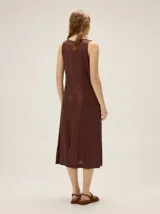 Vestido midi negro de lino con escote en V, sin mangas, de corte recto y holgado, con detalle de estampa abstracta en el lateral inferior.