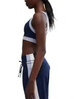 Top deportivo azul marino con contorno blanco y detalles en lila, de calce ajustado y breteles anchos.