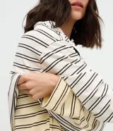 Blusa de corte oversize confeccionada en una mezcla de algodón y poliéster, con diseño de rayas horizontales. Presenta cuello redondo en color contrastante y mangas largas con caída relajada.