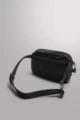 Riñonera deportiva plegable de tejido técnico, color negro. Cuenta con compartimento principal con cierre, bolsillo frontal con cierre, bolsillo plano posterior, asa ajustable con hebilla de liberación rápida y detalle de logo estampado.
