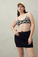 Falda corta de denim color negro con costuras verticales resaltadas y bolsillos delanteros diagonales. Diseño de corte recto.