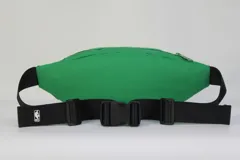 Riñonera verde de nylon con doble compartimento con cierre, ribete blanco decorativo y parche frontal con el logo de los Boston Celtics. Incluye correa negra regulable con hebilla.