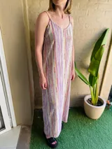 Vestido largo de tirantes finos con estampado de rayas verticales en tonos lila, naranja, verde y blanco.
