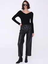 Pantalón ancho de cuero negro, de tiro alto y corte palazzo.