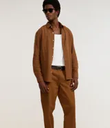 Pantalón de corte recto para hombre, color marrón, confeccionado en sarga. Cuenta con cintura con trabillas, cierre frontal tradicional y bolsillos laterales y traseros.