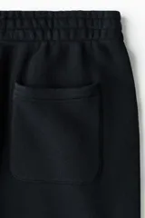 Pantalón deportivo de felpa con interior cepillado, de corte relajado, con cintura elástica con cordón de ajuste oculto, bolsillos al bies y bajos elásticos.