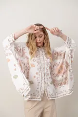 Camisa de seda modelo pañuelo, de color amarillo con estampado estilo mandala y flores, cuello redondo y cierre frontal con botones.