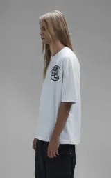 Remera blanca de corte oversize con estampa frontal de Goku sobre la nube voladora rodeado de las esferas del dragón.