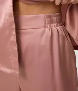 Pijama americano de satén color rosa viejo, compuesto por una camisa de manga corta con cuello solapa y botones frontales, y un pantalón largo de corte recto con cintura elastizada.