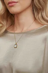 Collar de cadena fina dorada con un dije rectangular de cristal transparente engarzado en metal dorado.