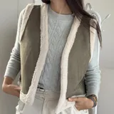 Chaleco estilo gamulán color verde militar con forro y bordes de corderito sintético blanco, diseño sin mangas.