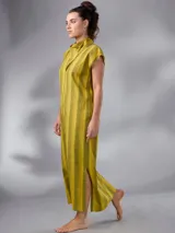 Vestido largo de lino y algodón con diseño de rayas verticales en tonos mostaza y verde. Presenta escote en V, cuello solapa ancho, mangas cortas con diseño capa, corte recto y lazo ajustable en la cintura.