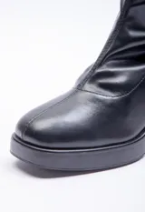 Bota de caña media color negro, con cierre lateral y taco cuadrado.