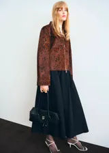 Chaqueta de cuero de potro color marrón con estampado tipo animal print en tonos oscuros, de corte recto y largo recortado. Cuenta con cuello camisero, cierre frontal de cremallera metálica y mangas largas amplias con puños rectos.