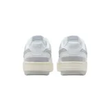Championes Nike Gamma Force de diseño urbano, con base blanca y detalles en plateado metalizado en el logo lateral y el talón. Presenta una suela de plataforma en tono crema con acabado gris en la parte inferior.
