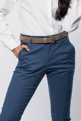 Pantalón de gabardina gris con corte clásico, bolsillos laterales y traseros, y cierre frontal con botón y cremallera. Incluye cinturón fino de cuero marrón con hebilla dorada.