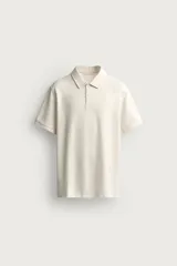 Polo de corte regular fit en tejido de algodón con estructura vertical color beige. Presenta cuello solapa, cierre frontal de botonadura y manga corta con rib.