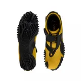 Championes Puma modelo Mostro OG Prime, color amarillo con detalles en negro. Presentan un diseño distintivo con suela de goma con relieve de tachones, cierre de velcro y la icónica franja lateral de la marca.