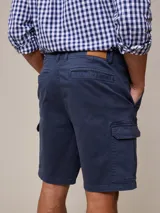 Bermuda cargo de sarga en color azul, con bolsillos laterales con solapa y cierre de botón. Diseño funcional con corte recto y ajuste cómodo.