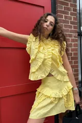 Falda corta amarilla con volados en cascada.
