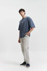 Pantalón de gabardina color azul marino, con diseño de cinco bolsillos, corte relajado, cintura elastizada con cordones ajustables y terminación recta sin puños.